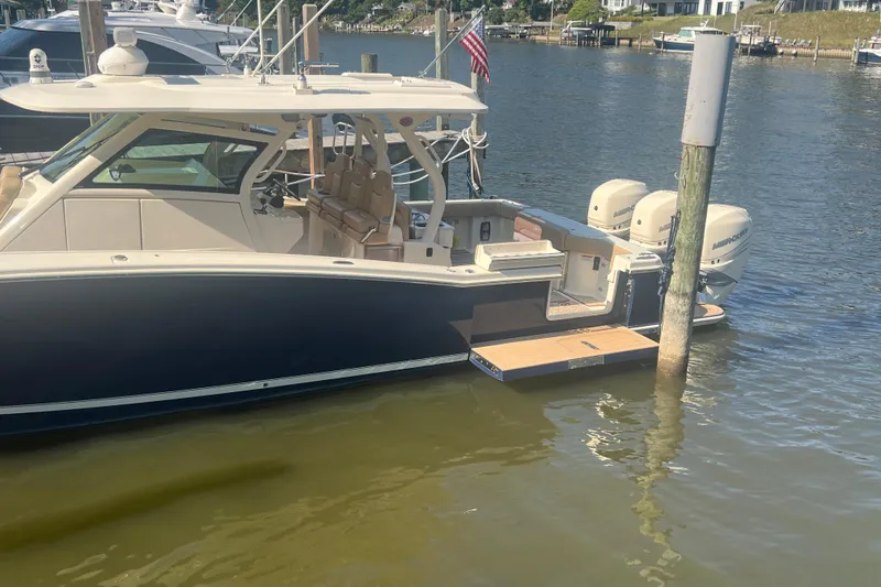 Slide: The Image of 2020 Scout 380 LXF boat docked in marina with twin outboard engines. - 4