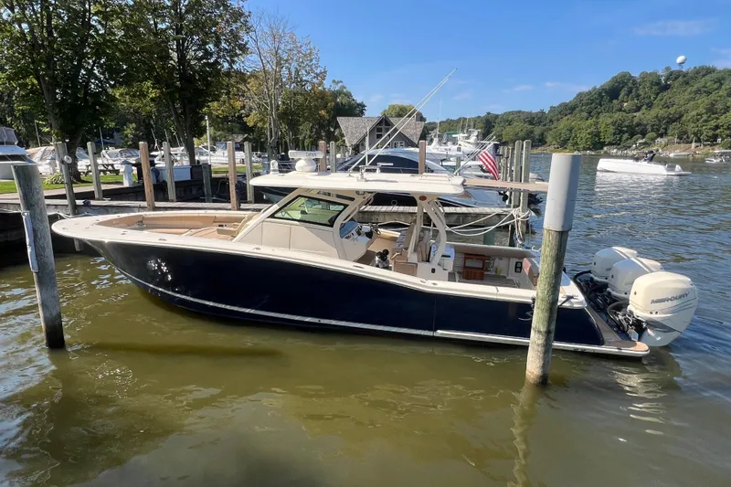 Slide: The Image of 2020 Scout 380 LXF boat docked in a scenic marina setting. - 5