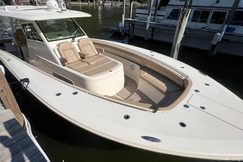Slide: The Image of 2020 Scout 380 LXF luxury boat docked, featuring spacious seating and sleek design. - 6