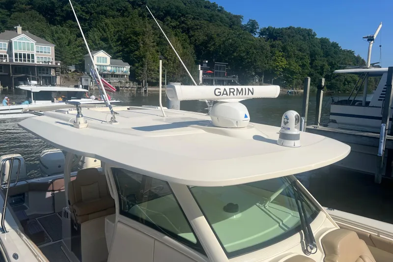 Slide: The Image of 2020 Scout 380 LXF boat docked, featuring Garmin and FLIR equipment on the roof. - 8