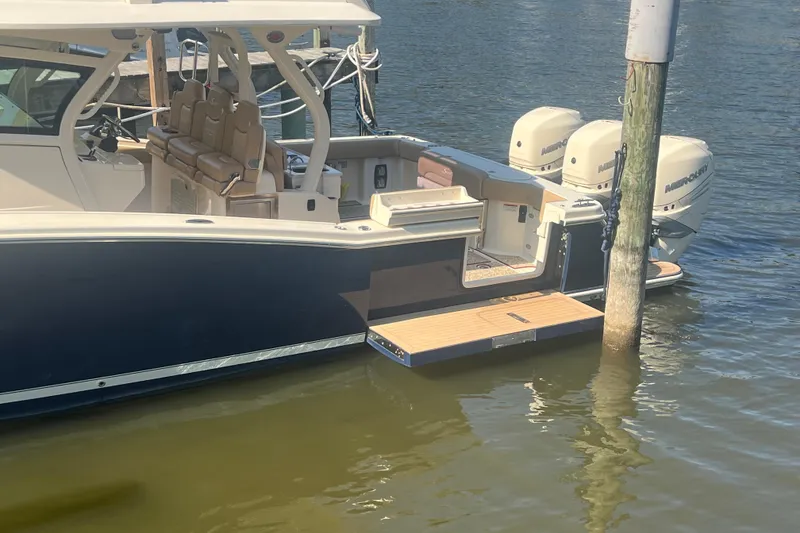 Slide: The Image of 2020 Scout 380 LXF boat docked, featuring dual Mercury engines and luxurious seating. - 9