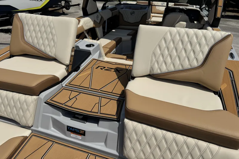 Slide: The Image of 2026 Tigé 24RZX boat interior with luxurious tan and cream diamond-stitched seating. - 11