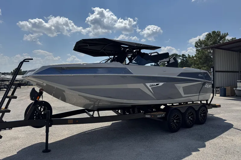 Slide: The Image of 2026 Tigé 24RZX boat on trailer under sunny sky, side view. - 18