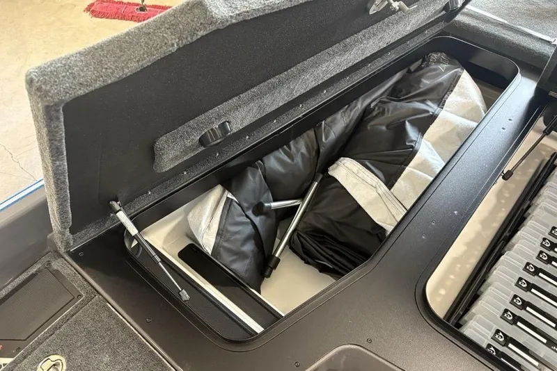 Slide: The Image of Open storage compartment in 2026 Skeeter FXR20 FLEX boat, showing organized gear and equipment. - 11