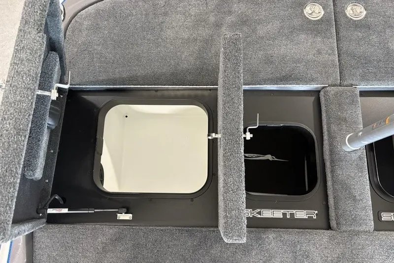 Slide: The Image of 2026 Skeeter FXR20 FLEX boat storage compartments with open hatches and carpeted interior. - 25