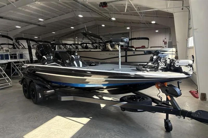 Slide: The Image of 2026 Skeeter FXR20 FLEX boat in showroom, sleek design, dual-axle trailer. - 3