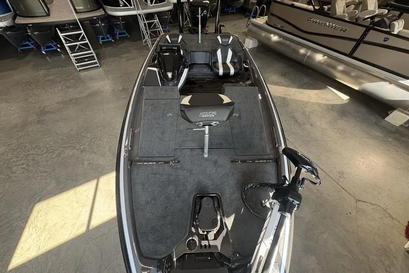 Slide: The Image of 2026 Skeeter FXR20 FLEX fishing boat interior in showroom, featuring seating and equipment. - 31