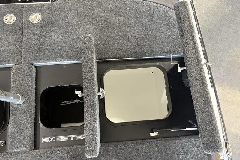 Slide: The Image of 2026 Skeeter FXR20 FLEX boat storage compartments with carpeted interior and open hatches. - 32