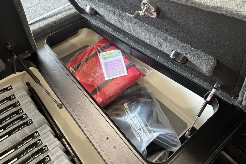 Slide: The Image of Storage compartment of 2026 Skeeter FXR20 FLEX boat with safety gear and tackle boxes. - 9