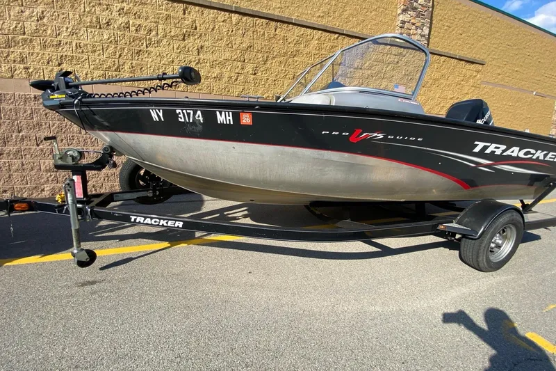Slide: The Image of 2011 Tracker Pro Guide V-175 Combo boat on trailer, parked outdoors. - 2