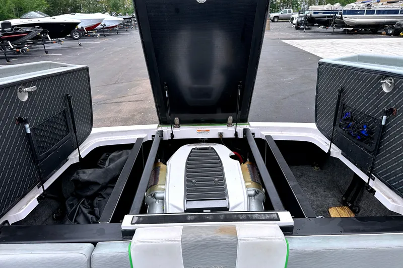 Slide: The Image of 2012 Nautique Sport Nautique 200 engine compartment with open hatches in a boatyard. - 11