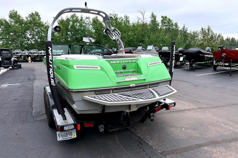 Slide: The Image of 2012 Nautique Sport Nautique 200 boat in parking lot, green exterior, rear view. - 6