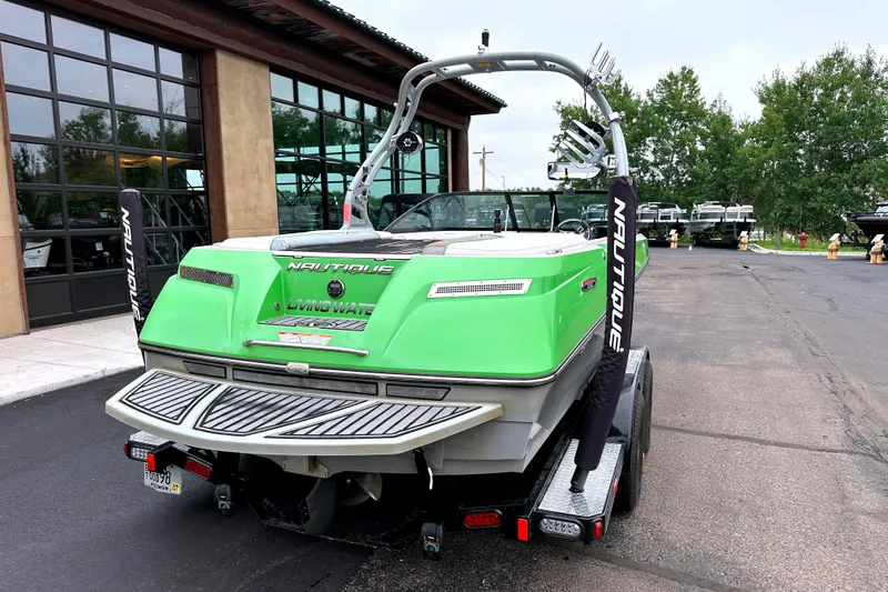 Slide: The Image of 2012 Nautique Sport Nautique 200 boat with green exterior, parked on a trailer. - 8