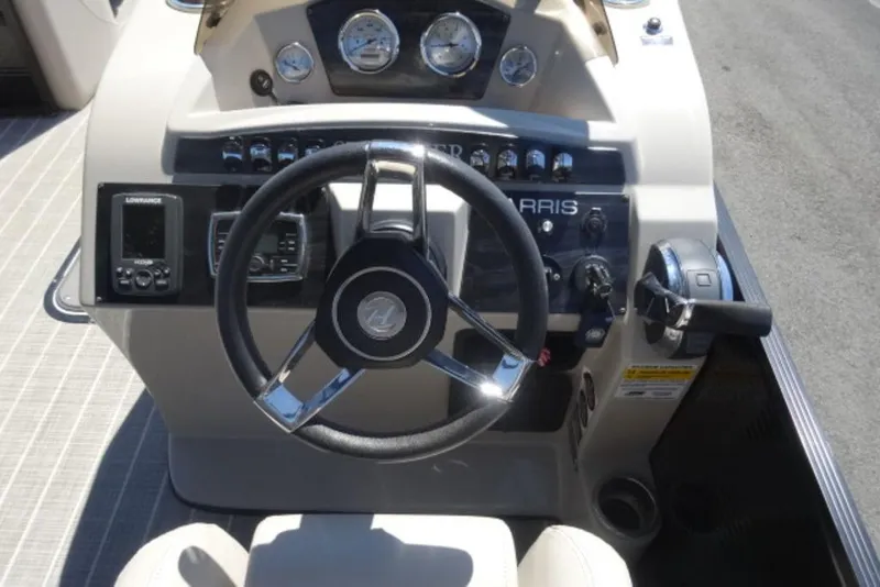 Slide: The Image of 2017 Harris Sunliner 240 boat dashboard with steering wheel and control panel. - 6