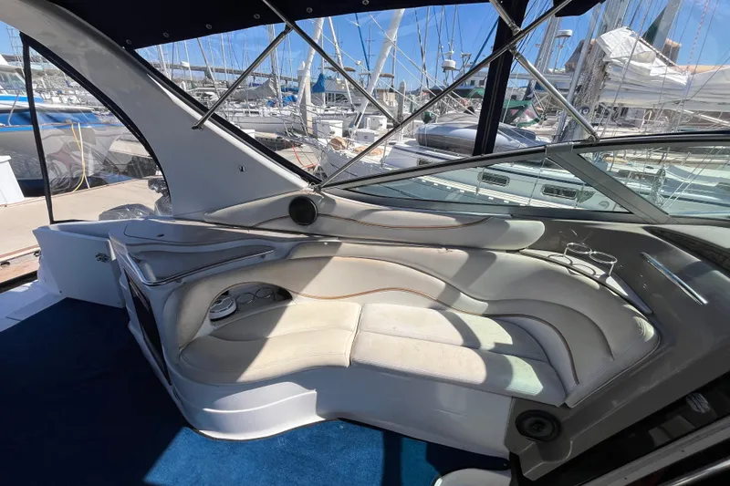 Slide: The Image of Interior of 2005 Larson-Cabrio 370 boat with white seating and marina view. - 13