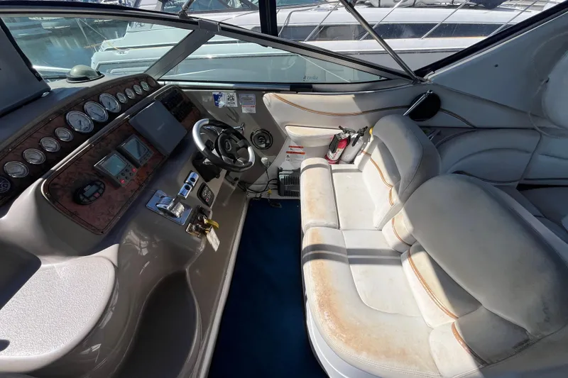 Slide: The Image of 2005 Larson-Cabrio 370 boat interior with steering wheel, dashboard, and seating area. - 18