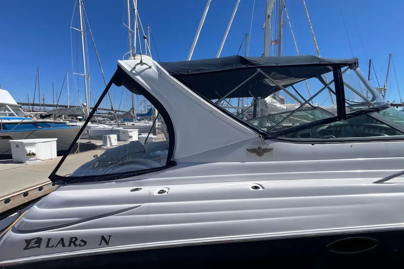 Slide: The Image of 2005 Larson-Cabrio 370 boat docked at marina under clear blue sky. - 2