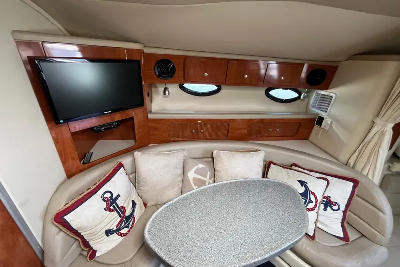 Slide: The Image of Luxurious 2005 Larson-Cabrio 370 yacht interior with TV, cushions, and elegant wood cabinetry. - 22