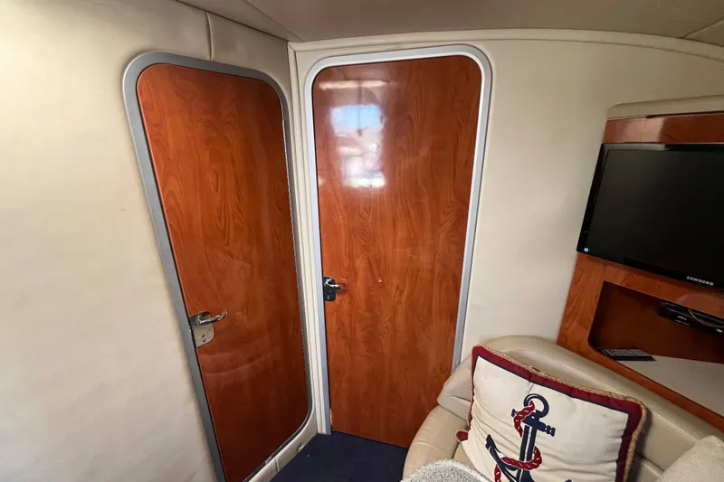 Slide: The Image of Interior of 2005 Larson-Cabrio 370 boat with wooden doors and a TV. - 24