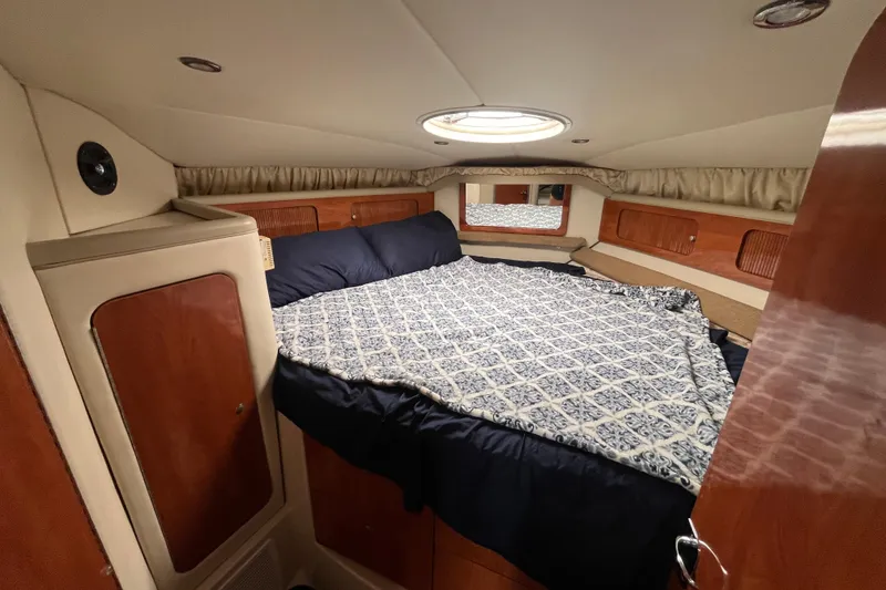 Slide: The Image of 2005 Larson-Cabrio 370 cabin interior with bed, wood paneling, and overhead lighting. - 25