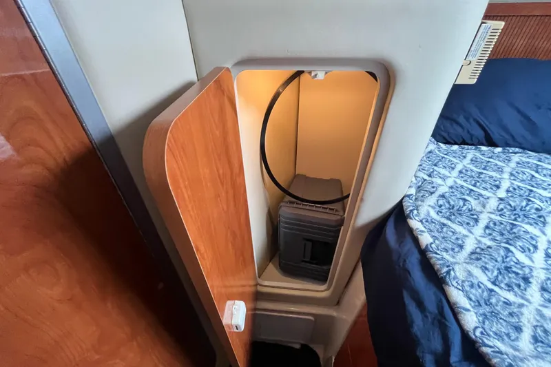 Slide: The Image of Open storage compartment in 2005 Larson-Cabrio 370 boat cabin with wooden door. - 27