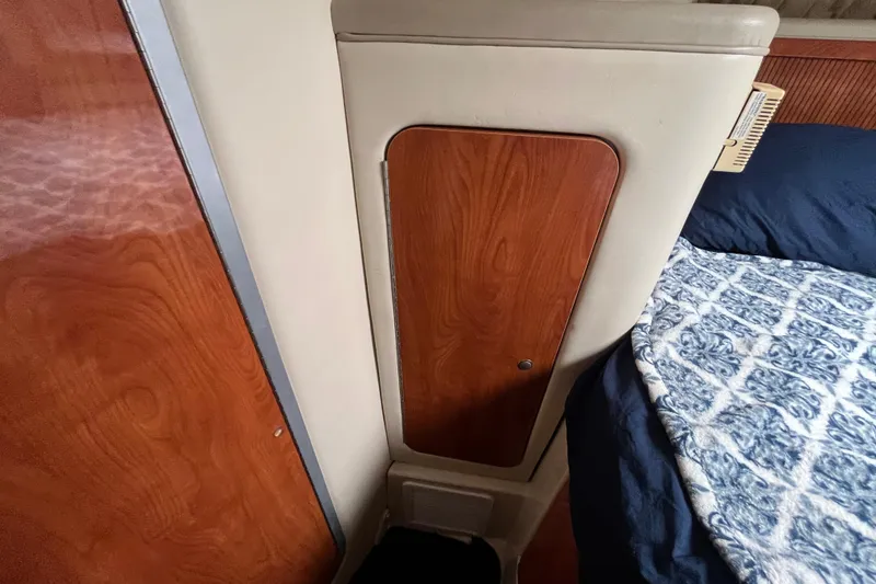 Slide: The Image of Interior of a 2005 Larson-Cabrio 370 boat with wood paneling and patterned bedding. - 28