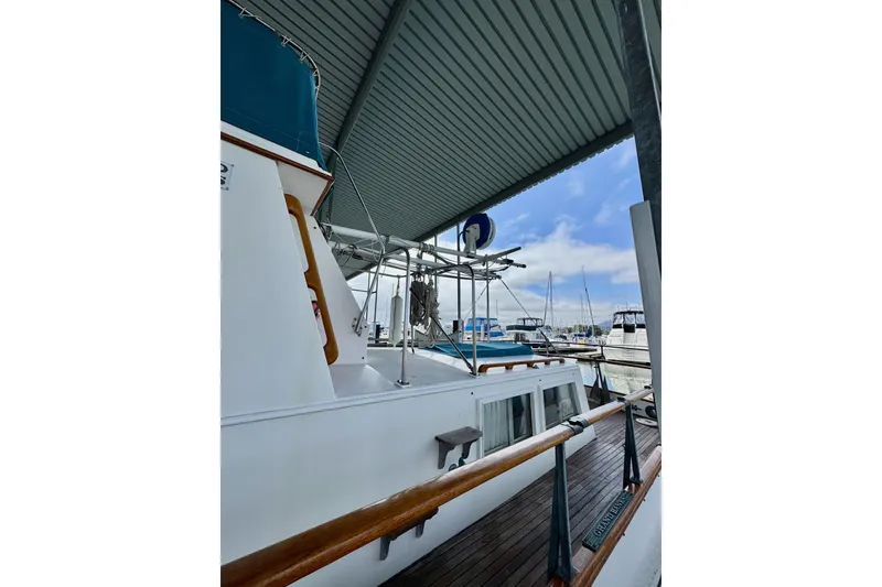 Slide: The Image of 1978 Grand Banks Classic boat docked under a covered marina with clear skies. - 13
