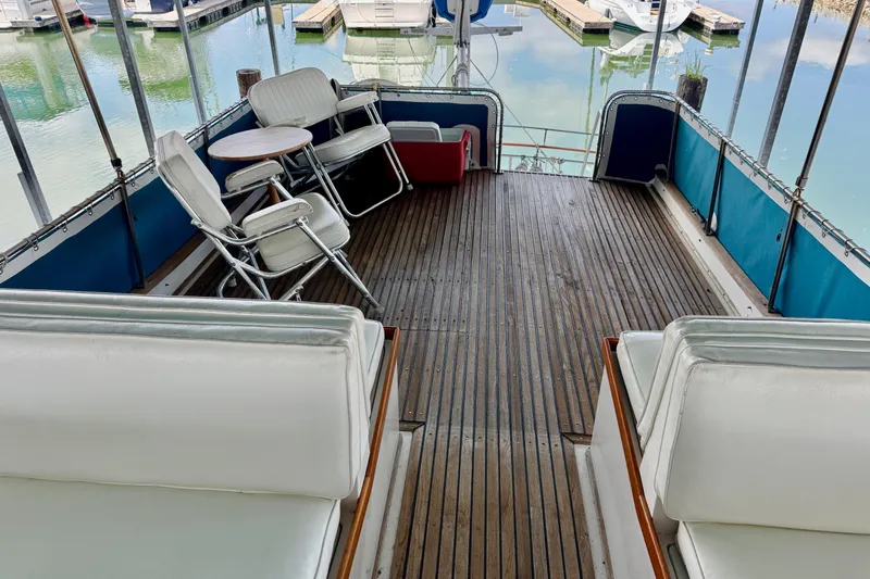 Slide: The Image of 1978 Grand Banks Classic yacht deck with white seating and wooden flooring. - 15