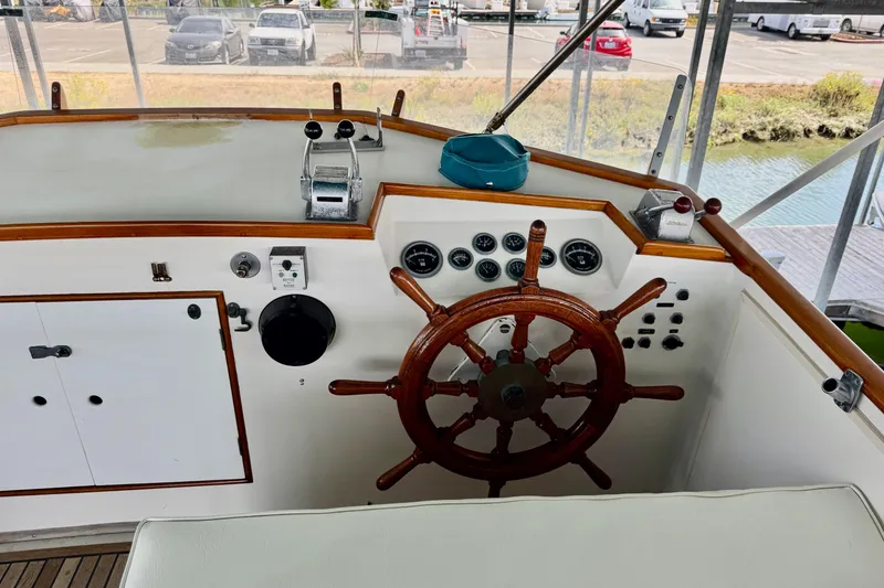 Slide: The Image of 1978 Grand Banks Classic boat helm with wooden wheel and control panel. - 18