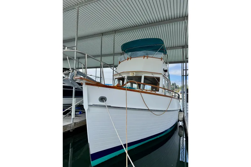 Slide: The Image of 1978 Grand Banks Classic boat docked under a covered marina. - 2
