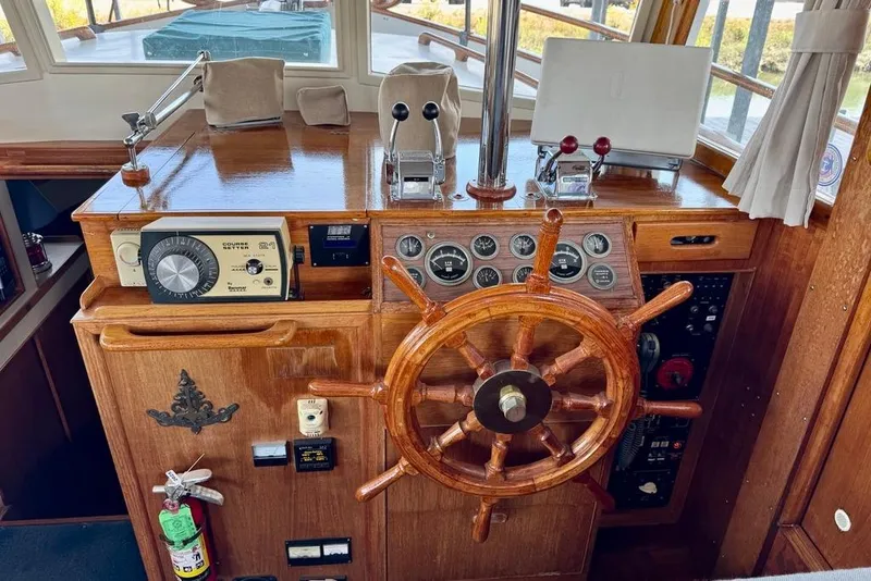 Slide: The Image of 1978 Grand Banks Classic helm with wooden wheel, gauges, and navigation equipment. - 25