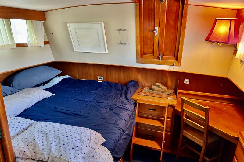 Slide: The Image of Cozy cabin interior of 1978 Grand Banks Classic with bed, wooden desk, and warm lighting. - 27