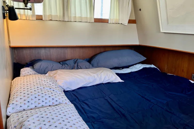 Slide: The Image of Cozy cabin bed in a 1978 Grand Banks Classic boat with blue bedding. - 28
