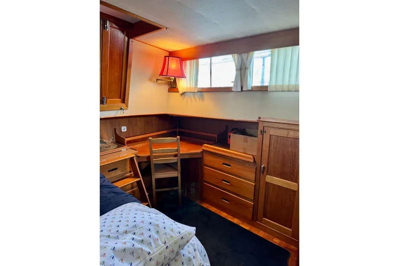 Slide: The Image of 1978 Grand Banks Classic cabin interior with wooden furniture and a cozy desk area. - 29