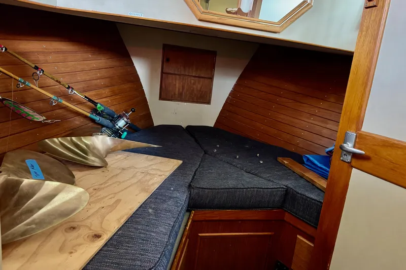 Slide: The Image of 1978 Grand Banks Classic cabin interior with fishing rods and brass propellers. - 32