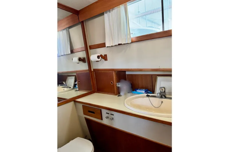 Slide: The Image of 1978 Grand Banks Classic yacht bathroom with sink, mirror, and wooden cabinetry. - 35