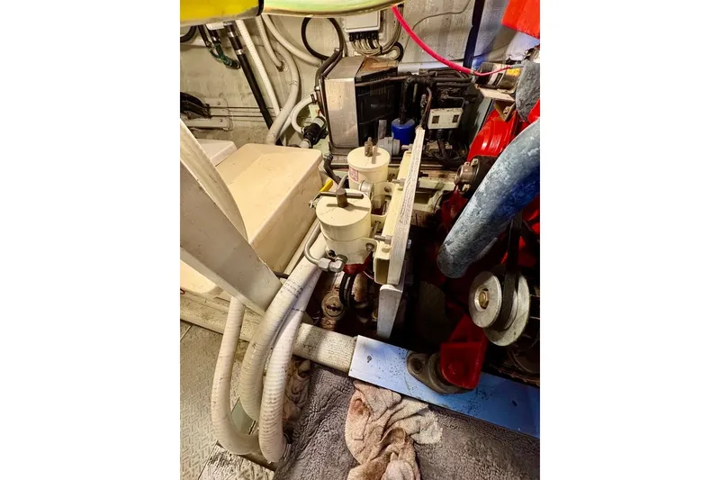 Slide: The Image of Engine room of a 1978 Grand Banks Classic boat, showcasing mechanical components and piping. - 49