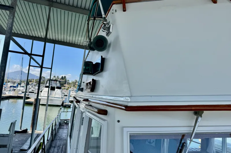 Slide: The Image of 1978 Grand Banks Classic boat docked in a marina, showcasing its upper structure and surroundings. - 51