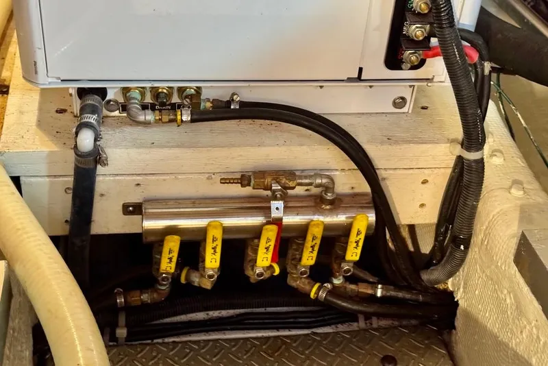 Slide: The Image of Engine room of a 1978 Grand Banks Classic boat with visible plumbing and wiring. - 52