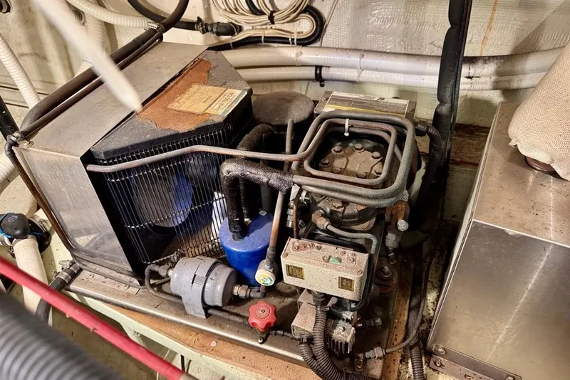 Slide: The Image of Engine room of a 1978 Grand Banks Classic boat, showcasing mechanical components and wiring. - 53