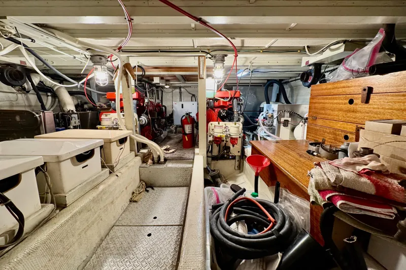 Slide: The Image of Engine room of a 1978 Grand Banks Classic boat, featuring equipment and storage. - 54
