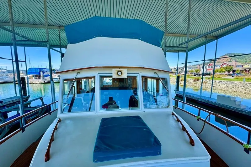 Slide: The Image of 1978 Grand Banks Classic yacht docked under a covered marina with scenic waterfront views. - 55
