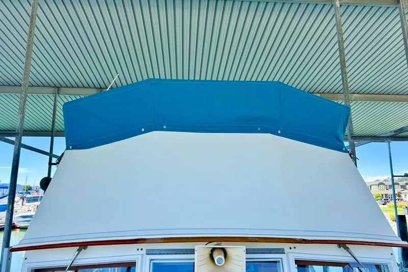 Slide: The Image of 1978 Grand Banks Classic boat with blue canopy under a metal roof. - 56