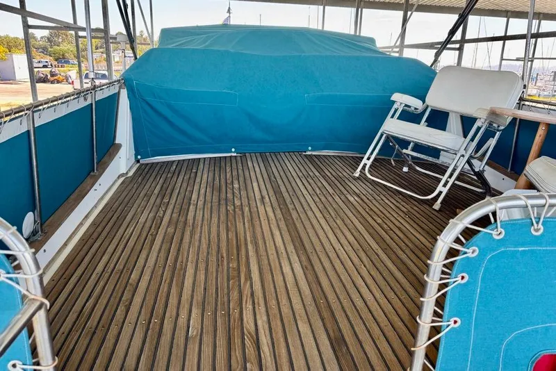Slide: The Image of 1978 Grand Banks Classic boat deck with blue seating and wooden flooring. - 58