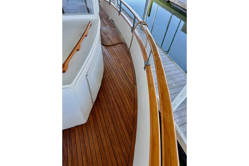Slide: The Image of 1978 Grand Banks Classic yacht with polished wooden deck and railing, docked at marina. - 6