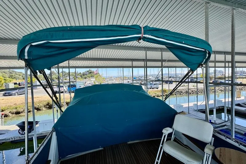 Slide: The Image of 1978 Grand Banks Classic boat with blue canopy in a marina setting. - 61