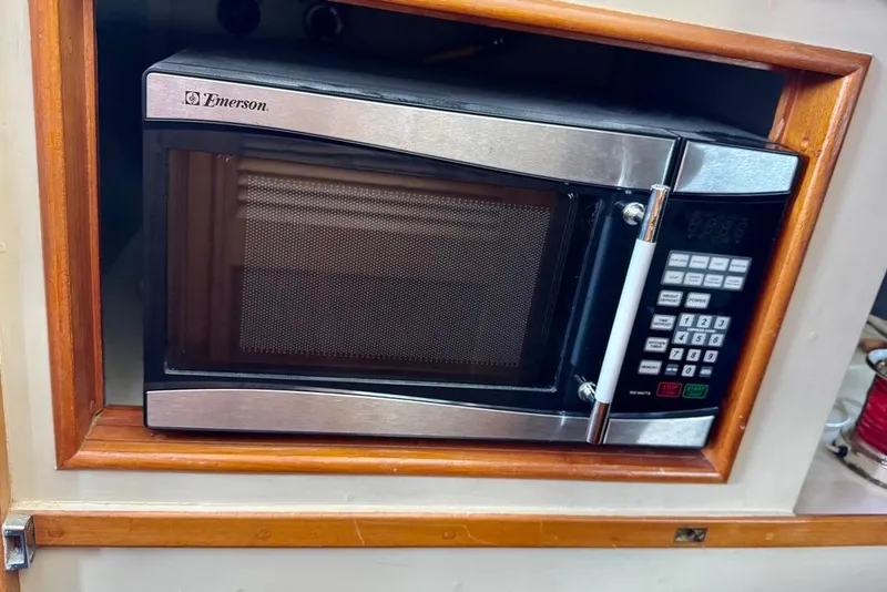 Slide: The Image of Emerson microwave in wooden cabinet on 1978 Grand Banks Classic boat. - 66