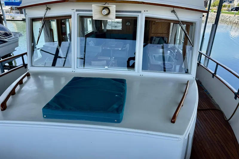 Slide: The Image of 1978 Grand Banks Classic boat deck with cushioned seating and wooden railings. - 7