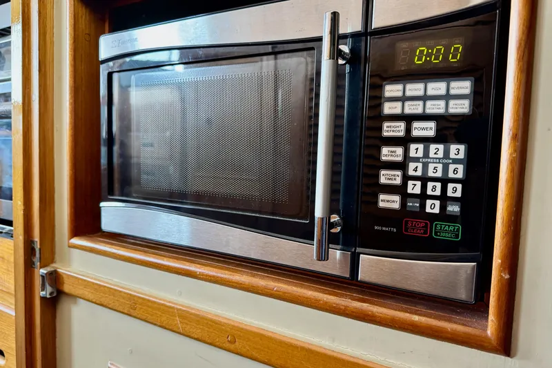 Slide: The Image of Microwave oven in 1978 Grand Banks Classic boat kitchen, featuring digital controls and wood paneling. - 70