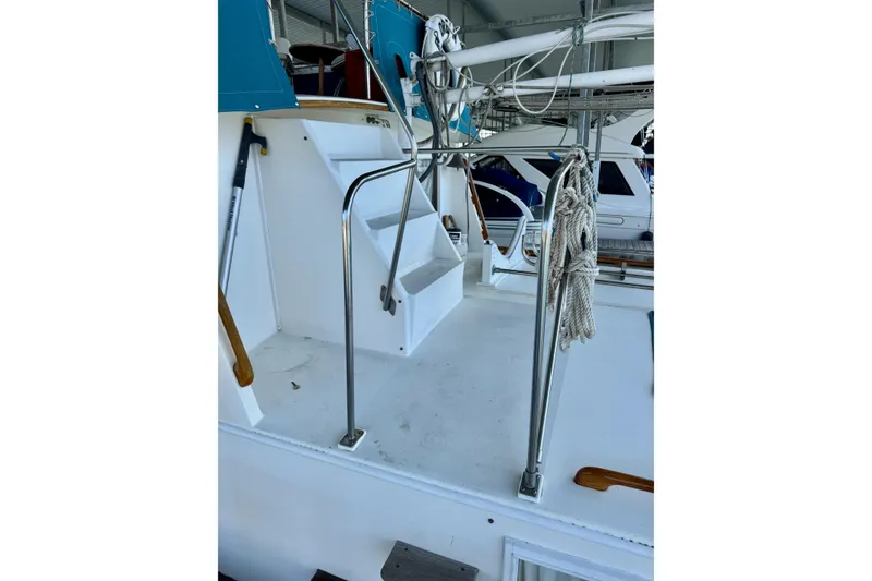 Slide: The Image of 1978 Grand Banks Classic yacht deck with stairs, railing, and coiled rope. - 73